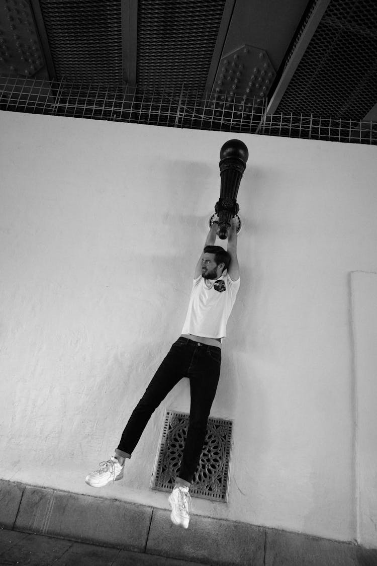 A Man Hanging On A Wall Lamp