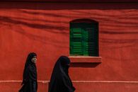 Muslim Women Walking by a Building