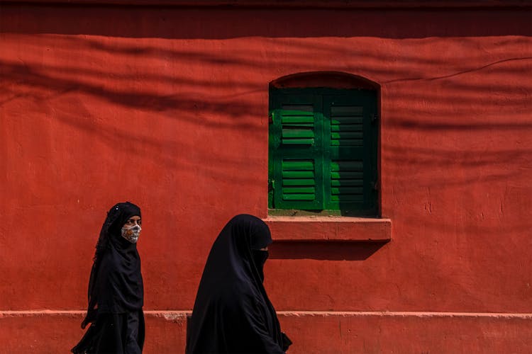 Muslim Women Walking By A Building