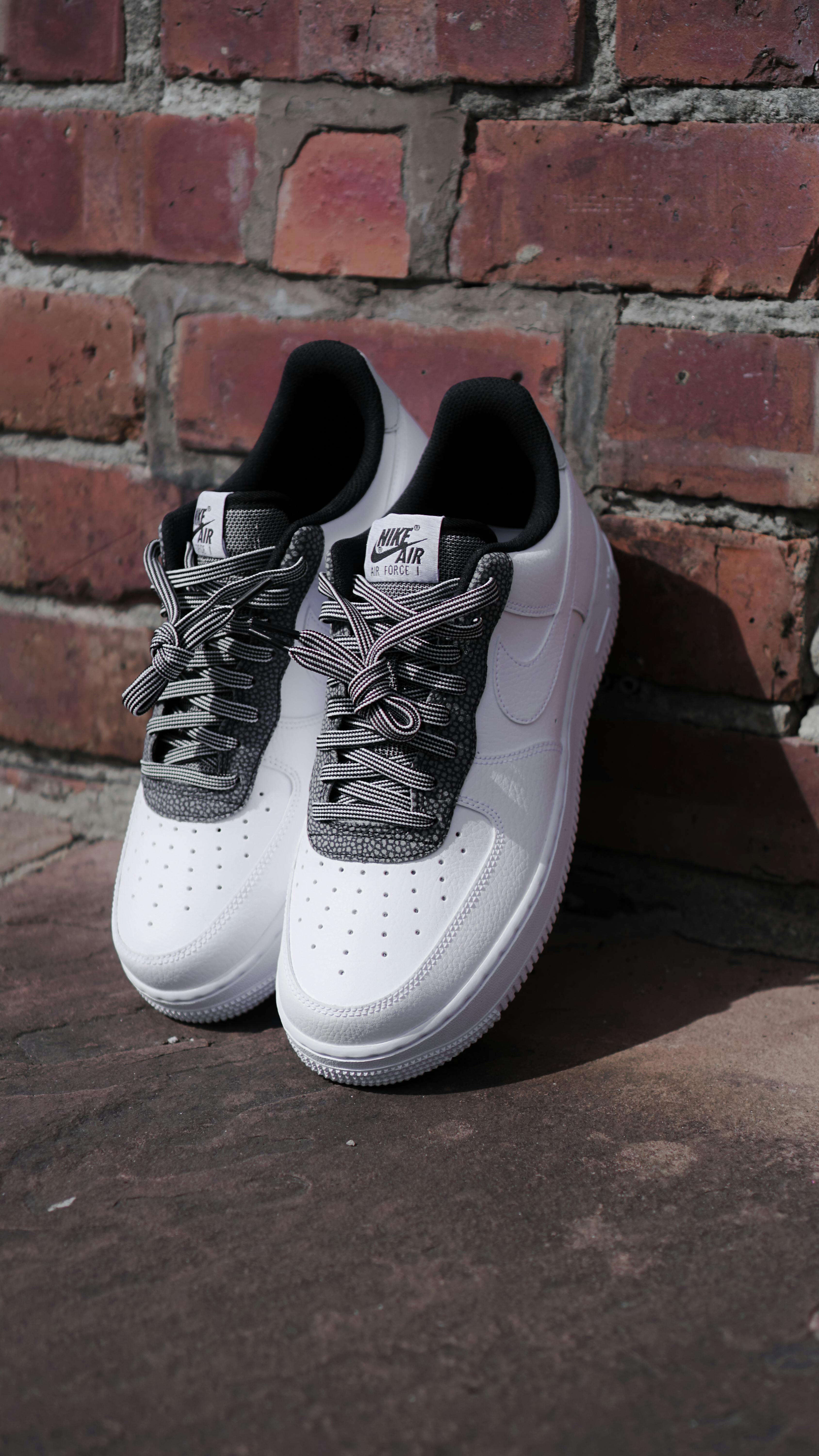 White Nike Air Force 1 Shoes Near the Brick Wall Free Stock Photo