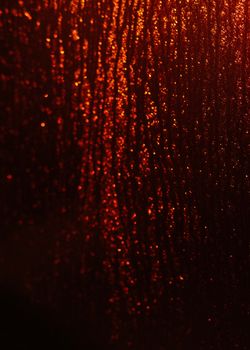 A mesmerizing display of red glittering textures with an abstract pattern captured in a vertical shot.
