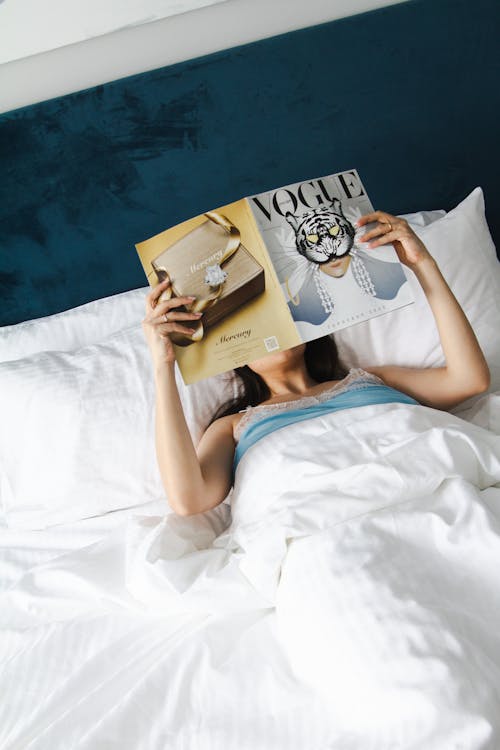 Woman Reading a Vogue Magazine in Bed 