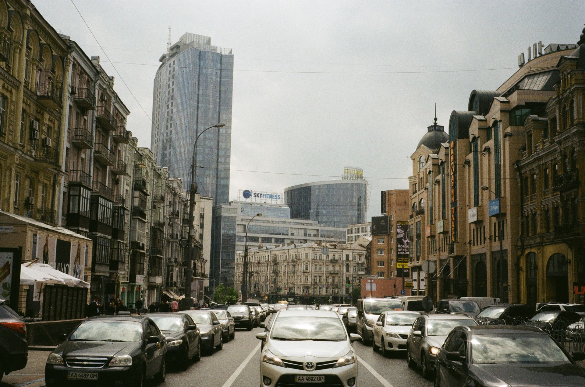Busy street in central Kyiv featuring cars and diverse architecture against an urban backdrop.