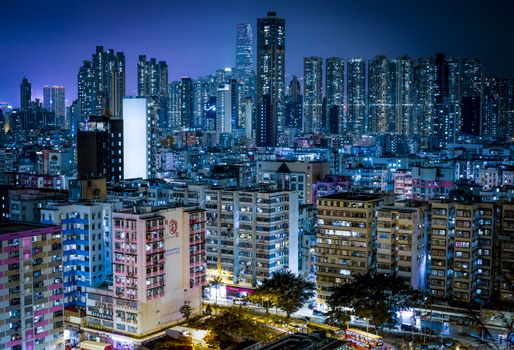 Stunning aerial view of Kowloon's illuminated cityscape at night, showcasing skyscrapers and vibrant city lights.