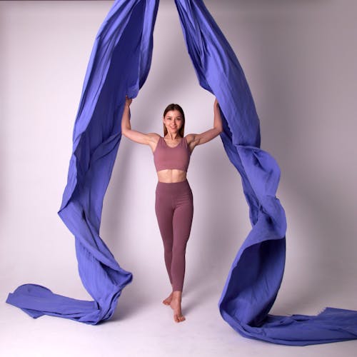 Woman in Crop Top and Leggings Holding on Aerial Silk Fabric