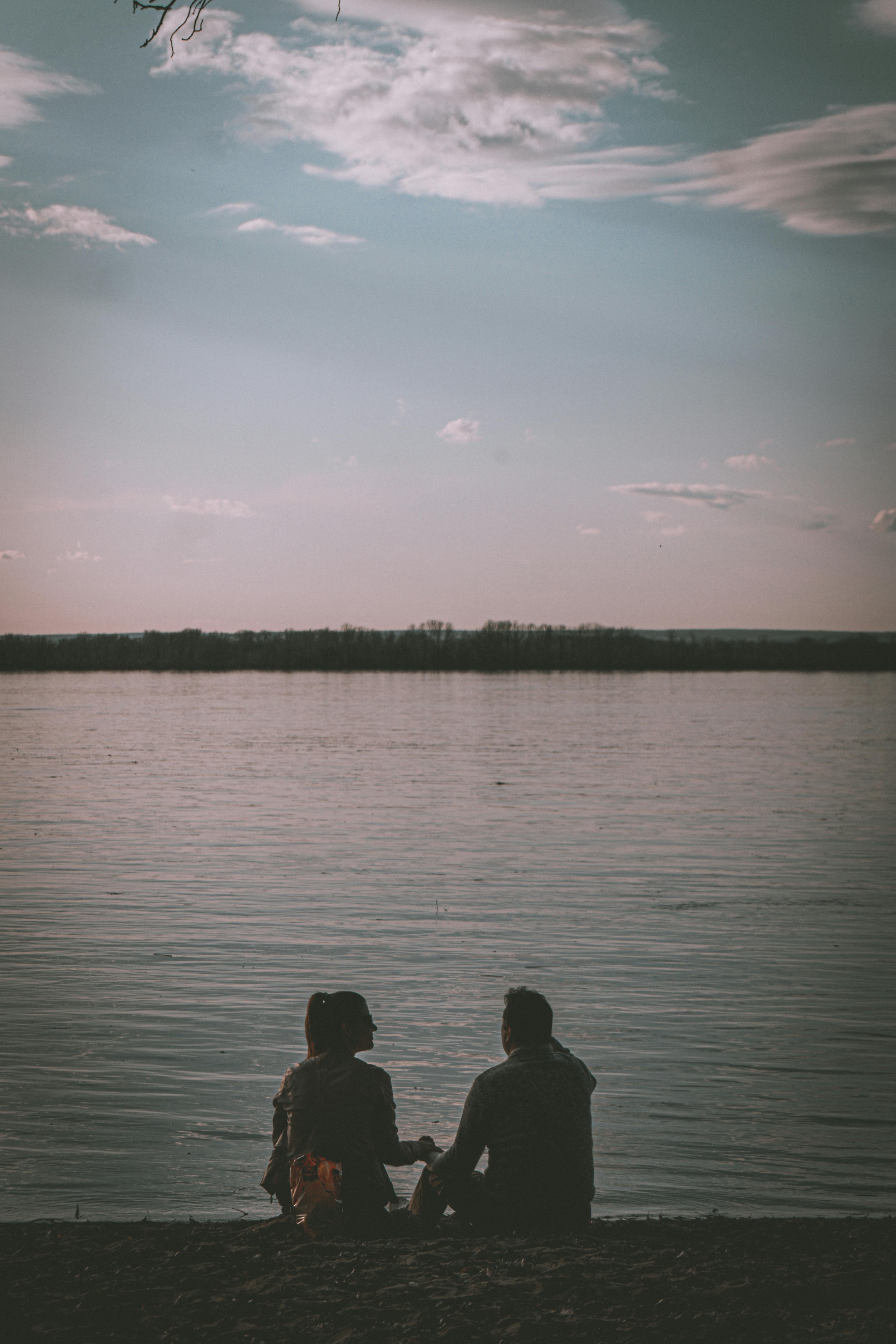 thumbnail image 2 of Back View Of Couple Sitting By Lake · Free Stock Photo 2 of 11
