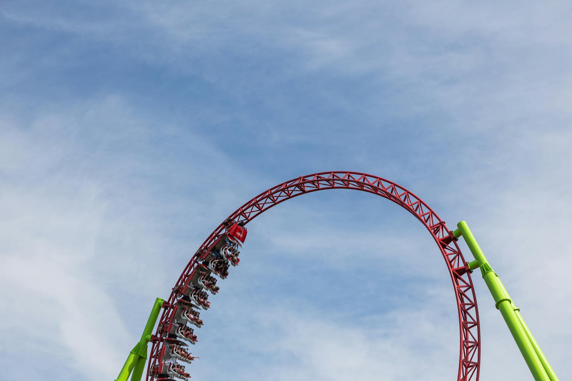 An exciting roller coaster performing a loop under a clear blue sky, capturing thrill and exhilaration.