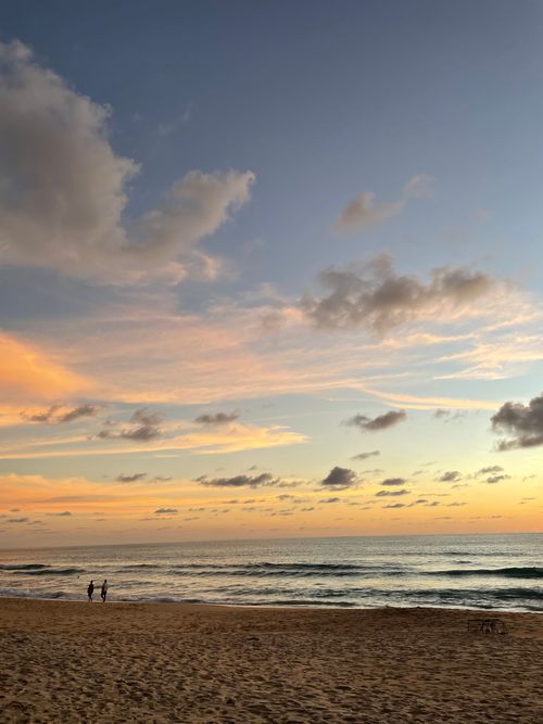 Free Beautiful sunset at Karon Beach, Phuket with vibrant clouds and serene shoreline. Stock Photo