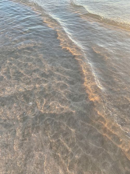 Free Serene sunlight glistening on shallow waves at Ko Libong Beach, Thailand. Stock Photo