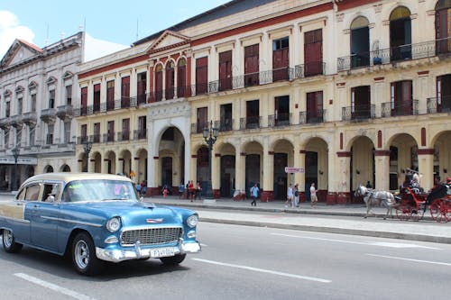 Classic Car on Road Beside Brown and White Building