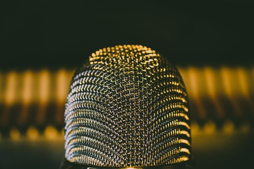 A detailed close-up shot of a modern microphone with a bokeh background, perfect for audio equipment themes.