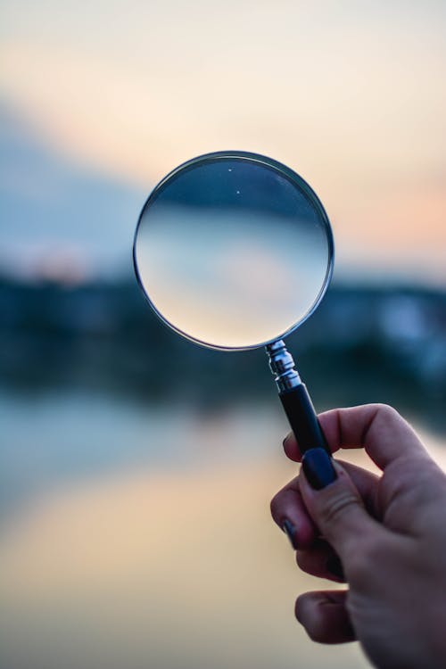 An image of a woman holding a magnifying glass. 