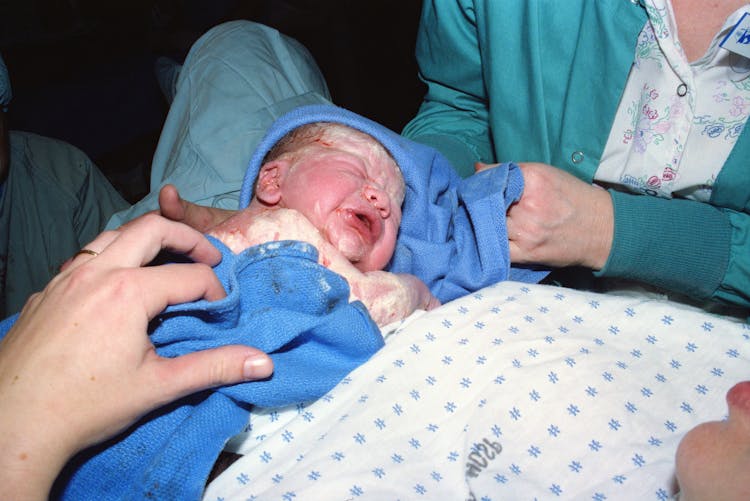 Cleaning Of A Newborn Baby With A Blue Fabric 