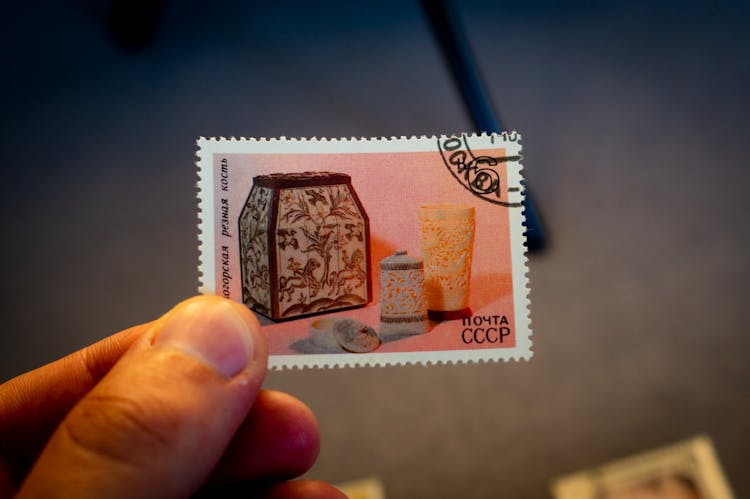 Person Holding A Postage Stamp