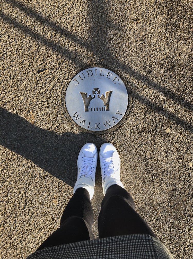 Person Standing Next To Jubilee Walkway Plaque