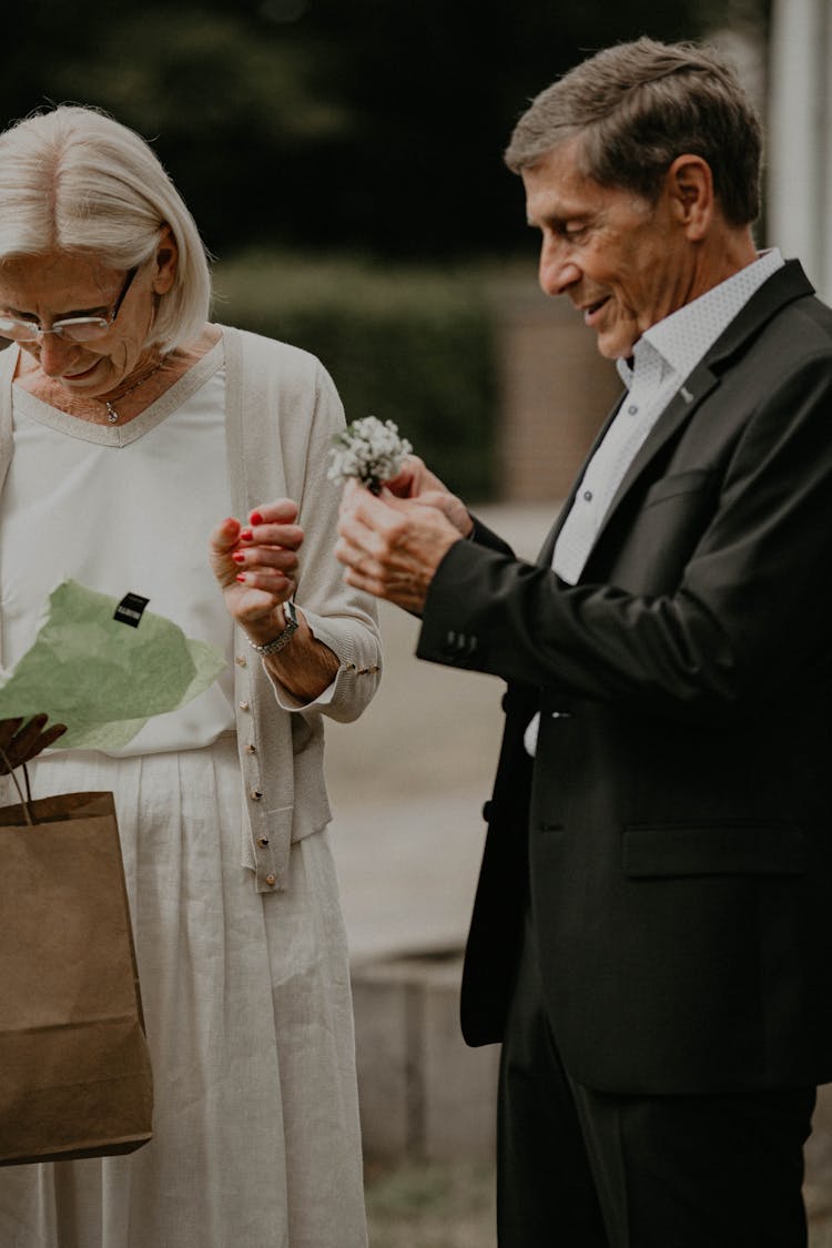 Elderly Couple In Elegant Clothing Opening Anniversary Gift