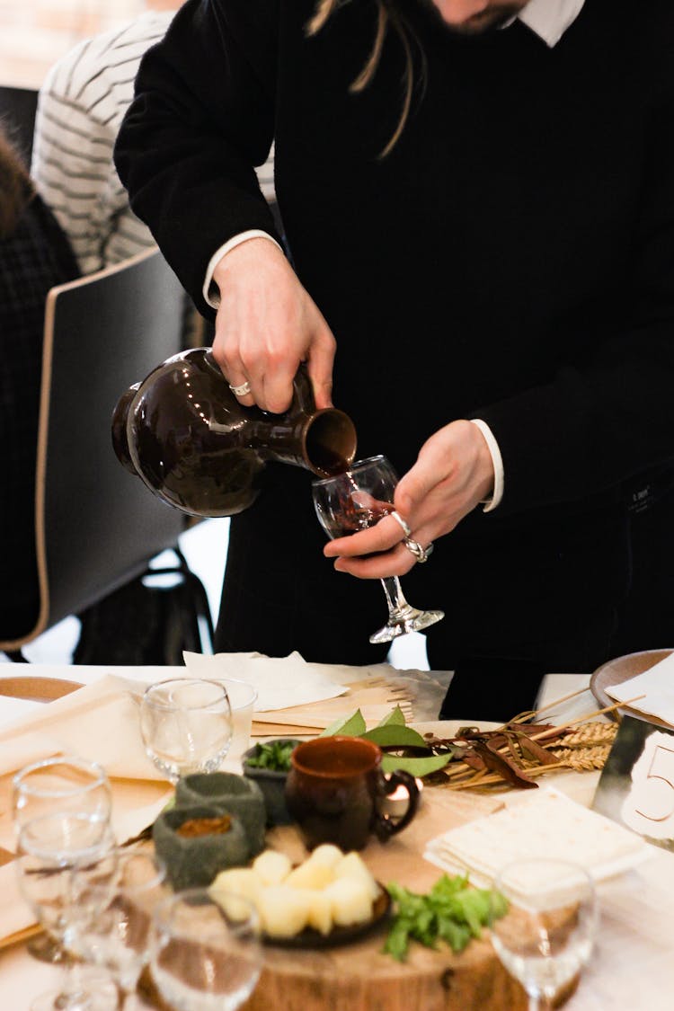 Man Pouring Wine On A Wine Glass 