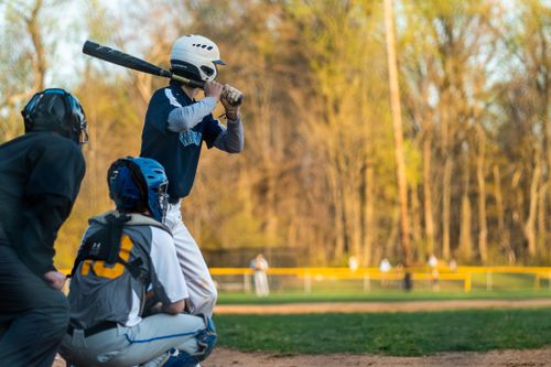 Free Baseball player in action at the plate during an outdoor game in a sunny park. Stock Photo