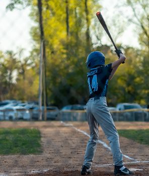A child baseball player ready to swing in a game on an outdoor field.