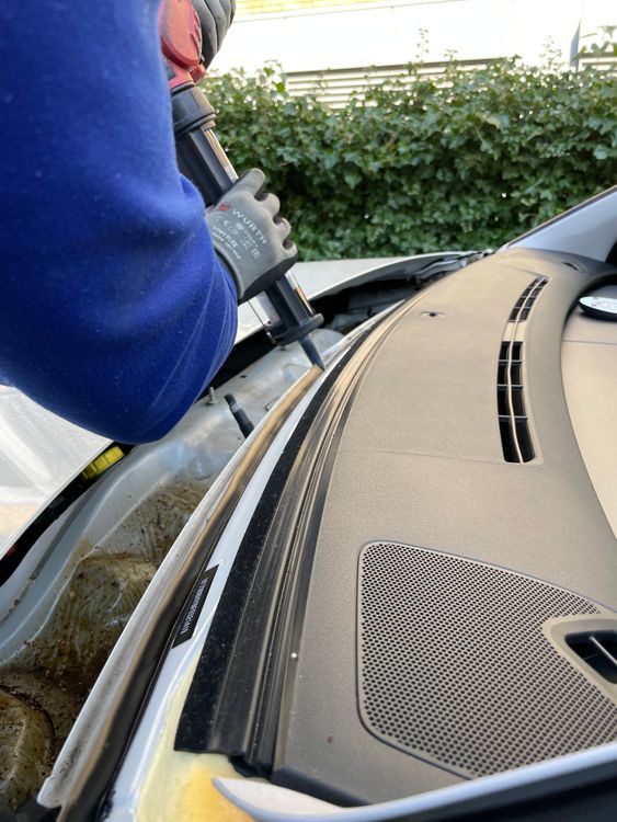 Tehničar popravlja vetrobransko staklo automobila, primena smole