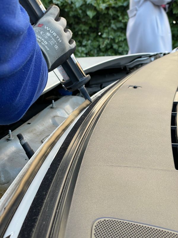 A technician setting and sealing a new vehicle windshield