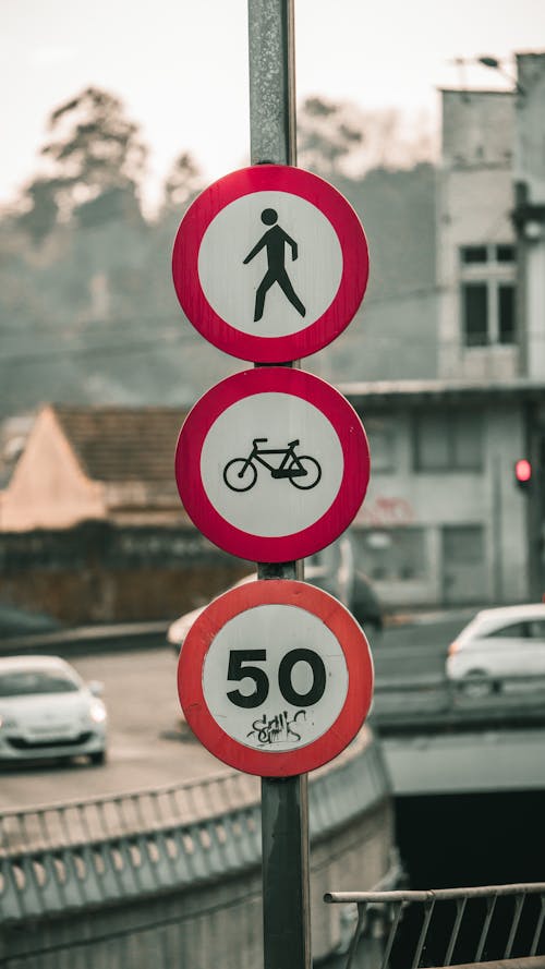 Red and White Street Signs Posted on Gray Steel Post