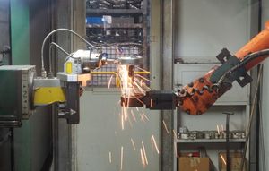 A robotic welding arm throwing sparks on an assembly line. Photo by alex on Pexels.
