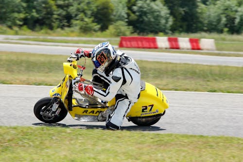Free A Person Riding a Yellow Motorbike on a Race Track Stock Photo