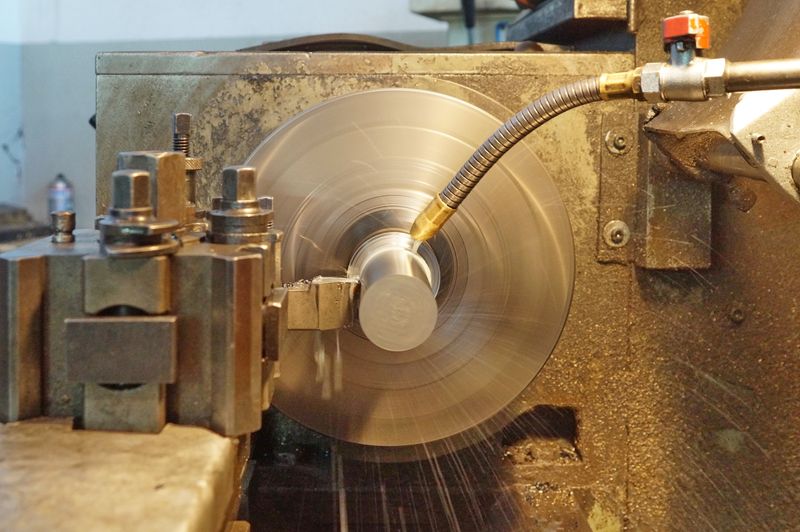 Precision metal lathe machining in an indoor workshop