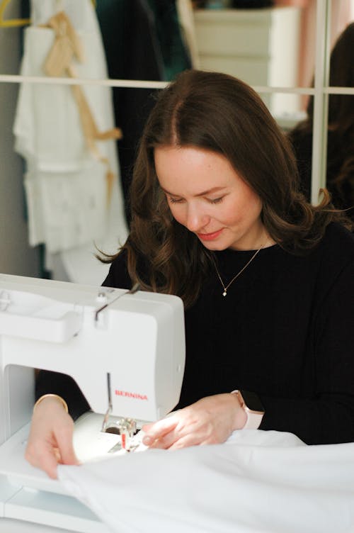 Free Woman in Black Long Sleeve Shirt Using White Sewing Machine Stock Photo