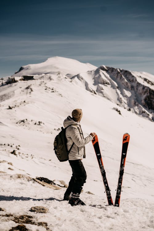 Free Skier Standing Next to the Skis in the Mountains  Stock Photo