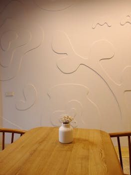 Modern minimalist room featuring a vase on a wooden table against an embossed wall.