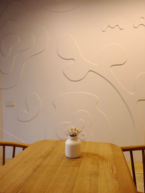 Free Modern minimalist room featuring a vase on a wooden table against an embossed wall. Stock Photo