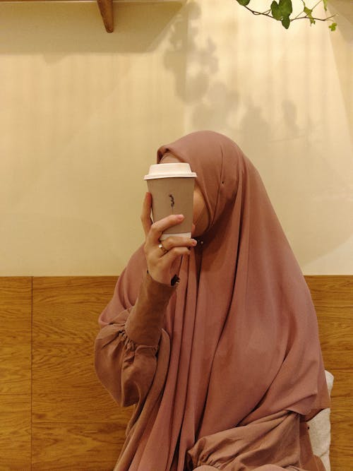 A Woman Wearing Hijab Holding a Paper Cup of Coffee