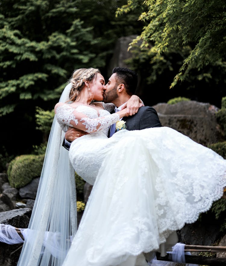 Groom Carrying The Bride And Kissing Her