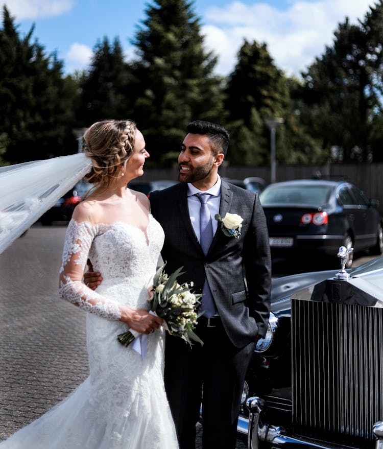 Bride And Groom Walking Together At A Parking Lot