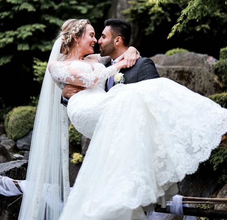 Groom Carrying The Bride And Smiling 