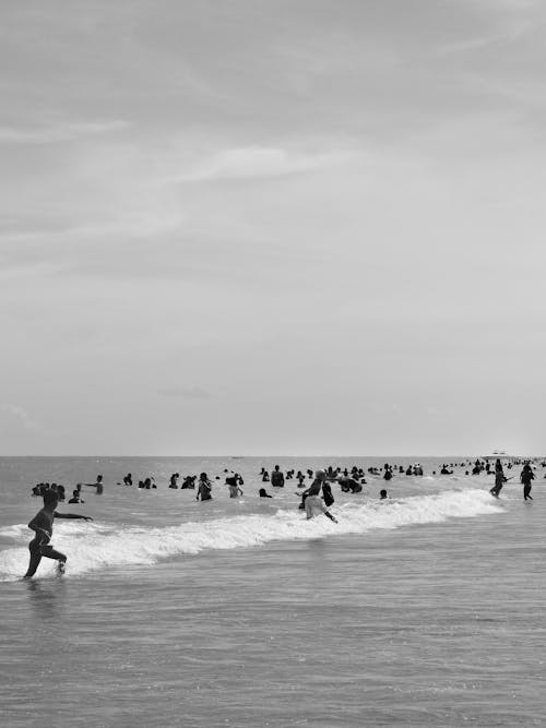 Grayscale Photo of People at a Beach