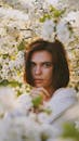 Portrait of a Woman Standing Among Tree Branches in Blossom