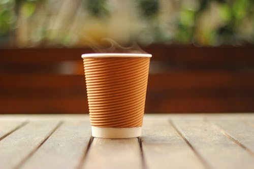 Selective Focus Photo of White and Brown Disposable Cup