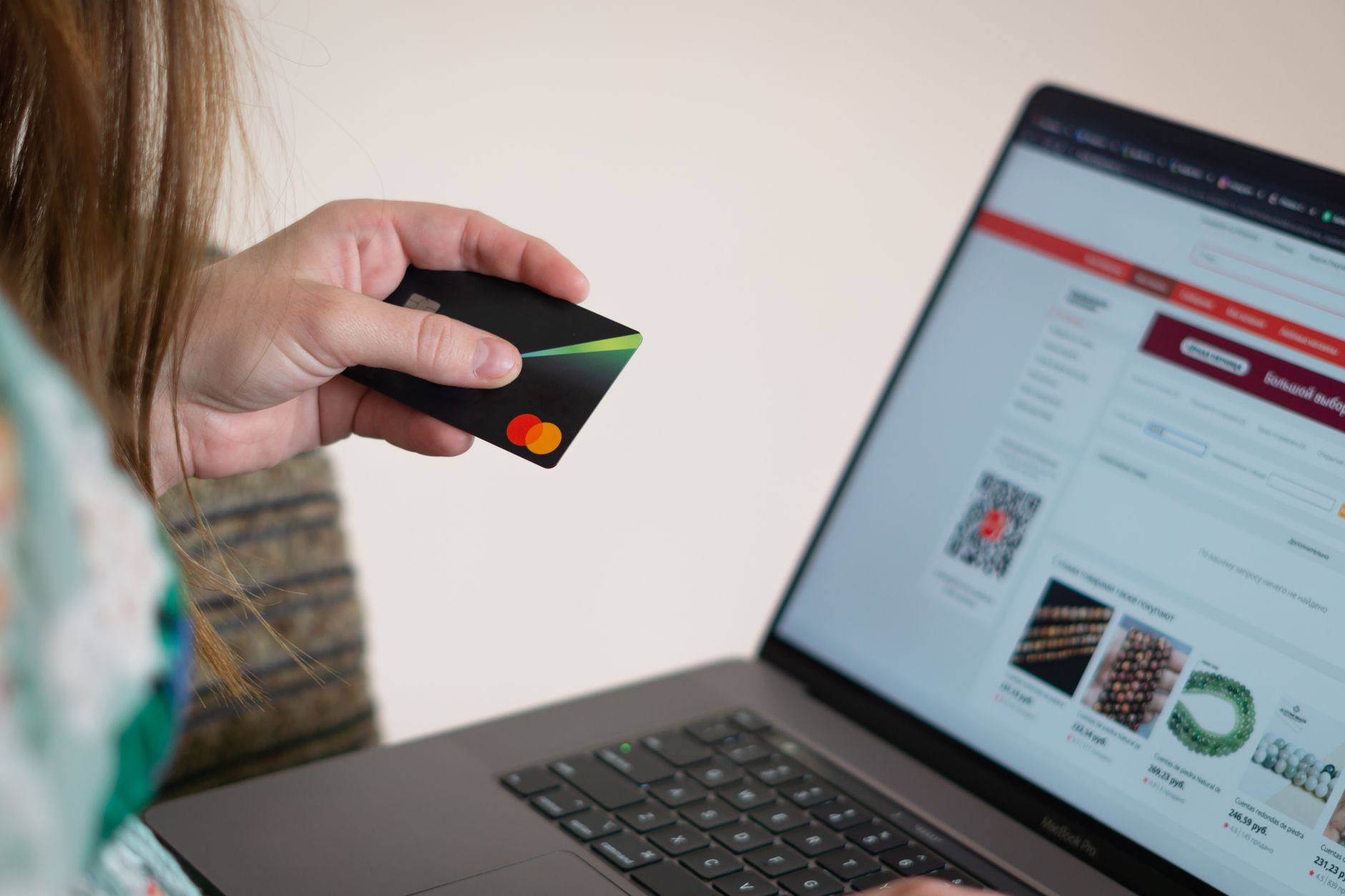 Femme réalisant un achat en ligne avec sa carte bancaire sur un site e-commerce