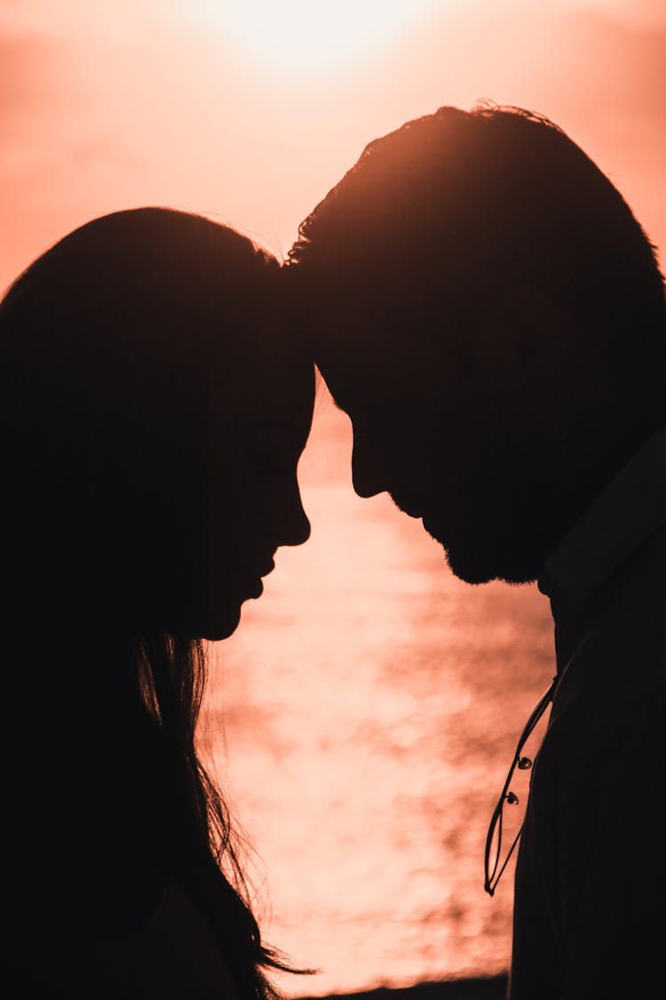 Silhouette Of A Woman And Man Leaning Towards Each Other