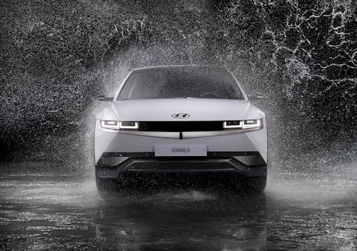 бесплатная Hyundai Ioniq 5 едет по мокрому полу, брызгая водой Стоковое фото