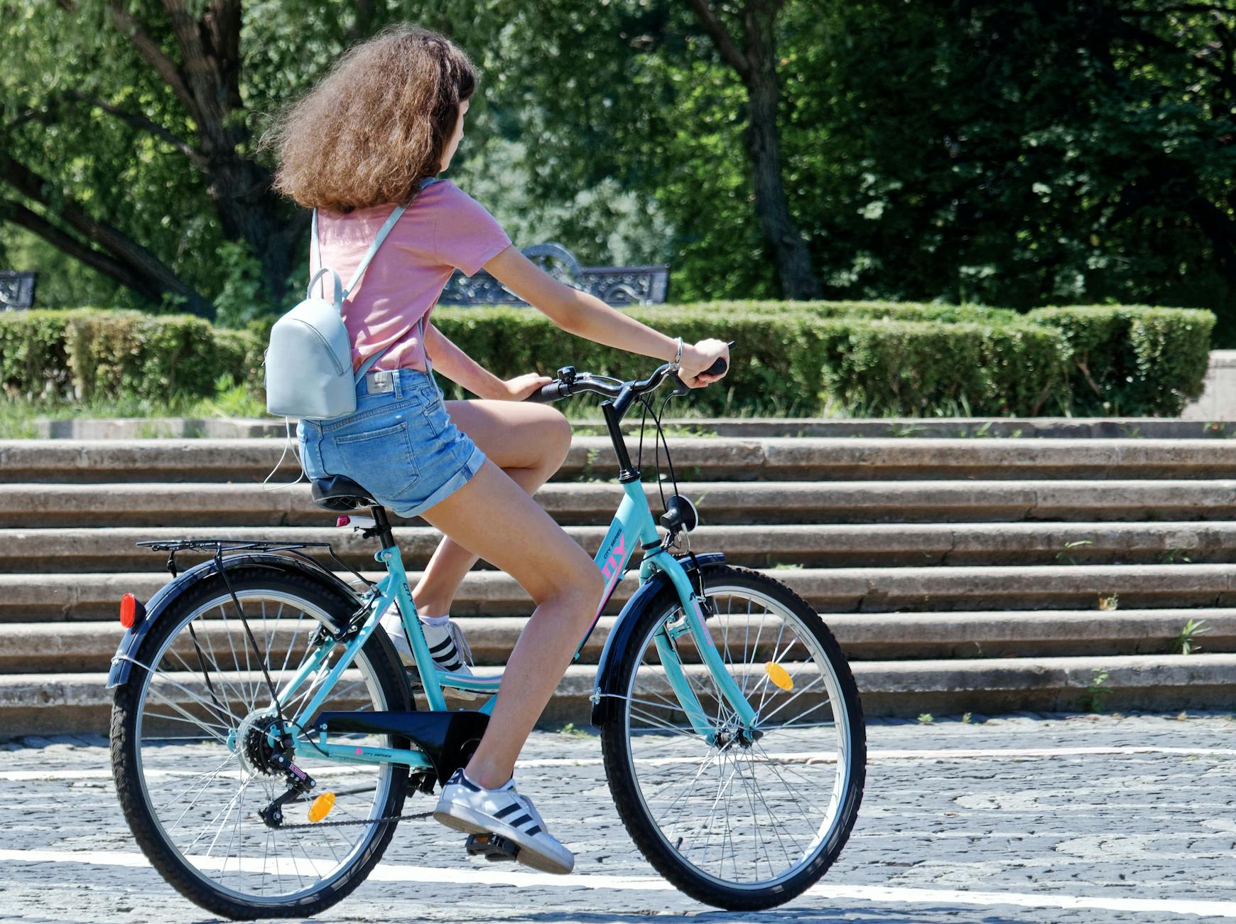 Woman Riding Bicycle Near Concrete Stairs