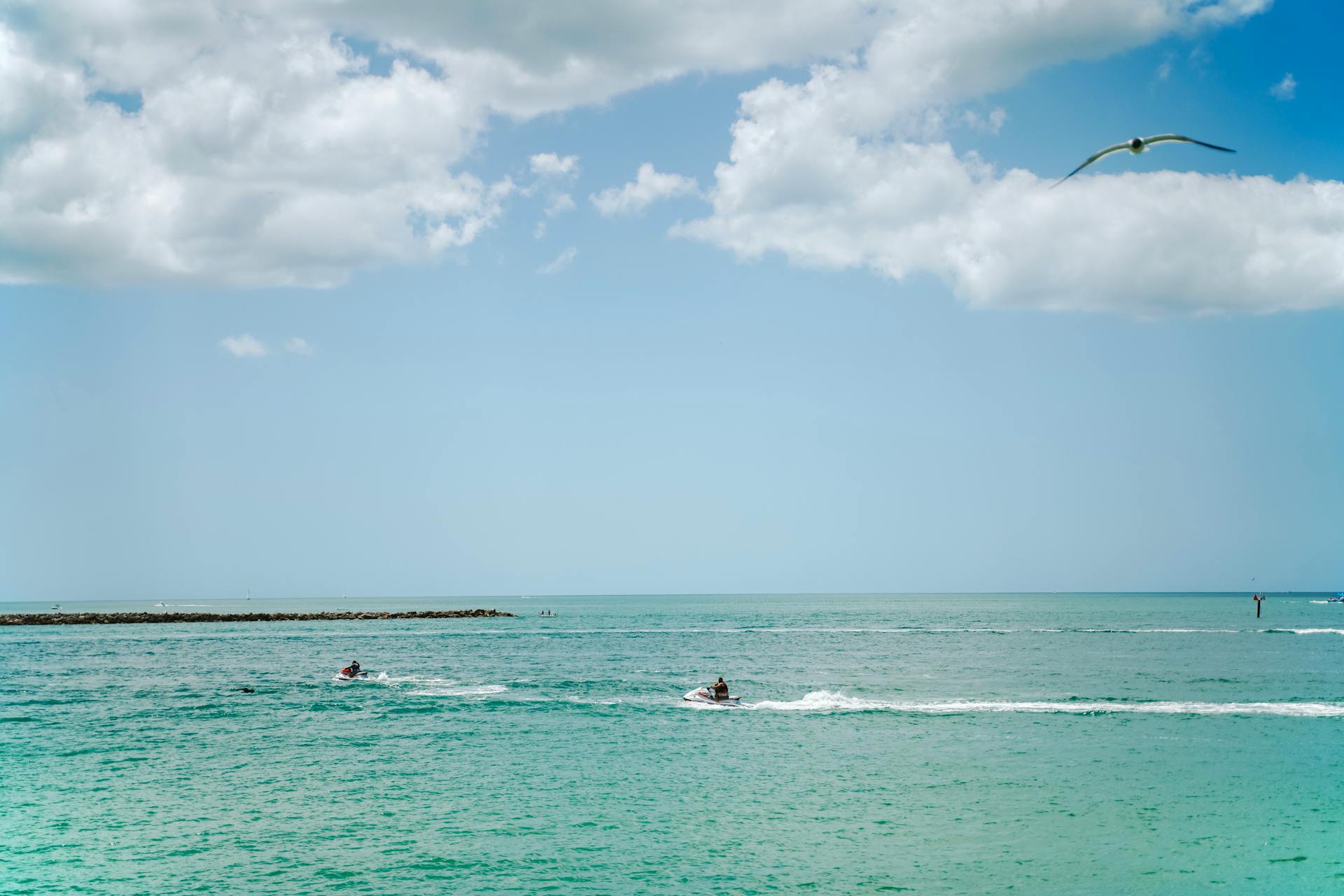 Experience a thrilling jetski ride under a bright sky on the vibrant blue waters of Clearwater Beach, Florida.