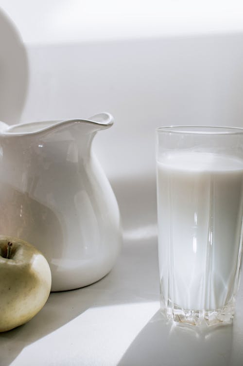 White Ceramic Pitcher Beside a Glass of Milk