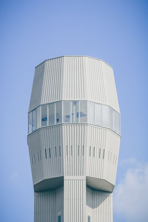 Free Vertical shot of a modern water tower with windows against a clear blue sky. Stock Photo