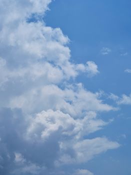 A calming scene of fluffy white clouds against a bright blue sky, evoking peace.
