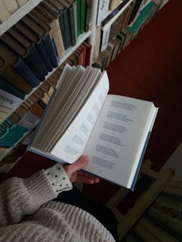Woman reading a book in a library, showcasing the love for literature and knowledge.
