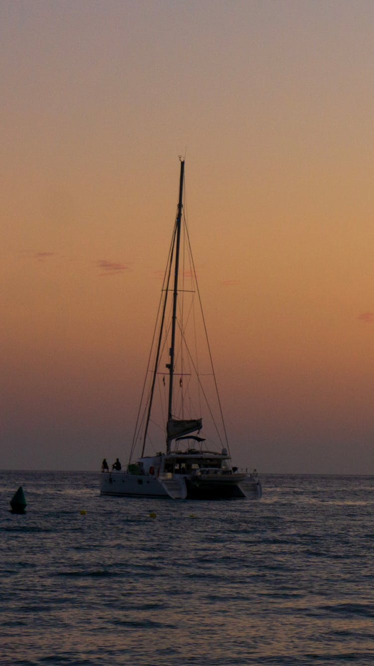 A Yacht Sailing On The Sea During Sunset